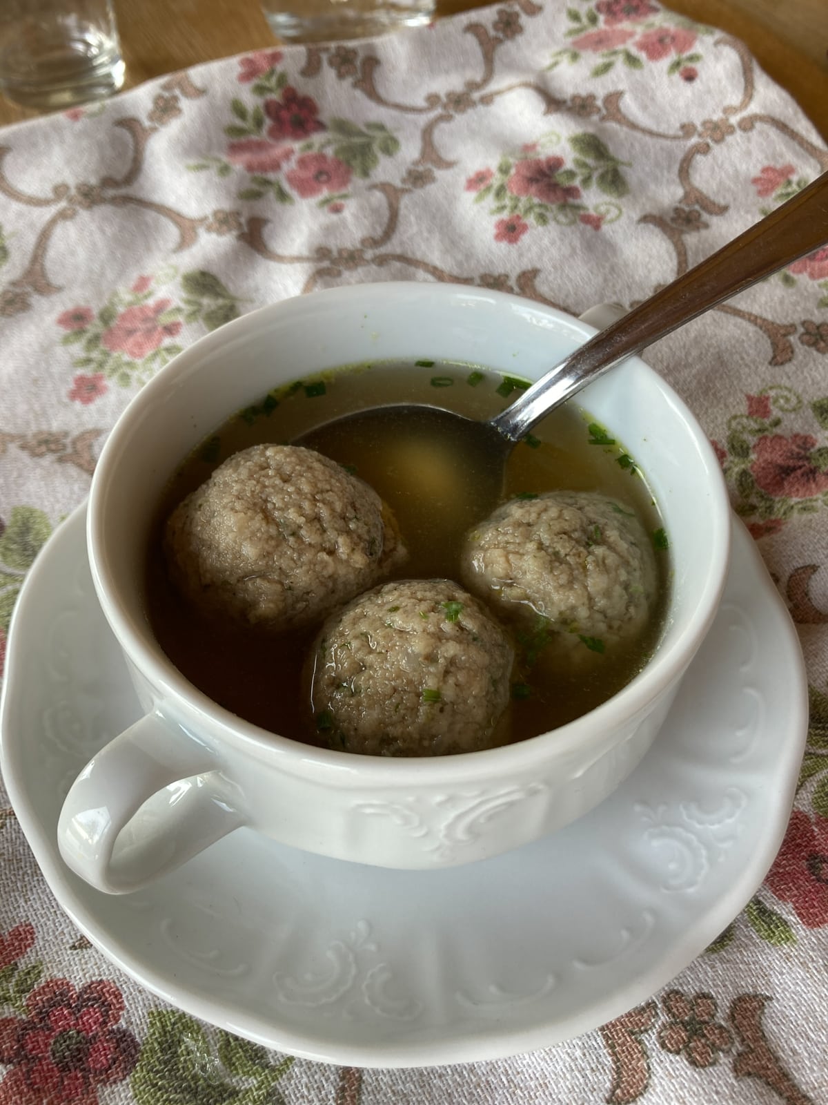 Drei Leberknödel in traditioneller Suppenschüssel mit Henkeln und Untertasse.