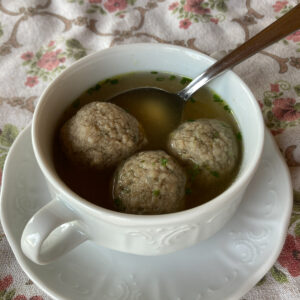 Drei Leberknödel in traditioneller Suppenschüssel mit Henkeln und Untertasse.