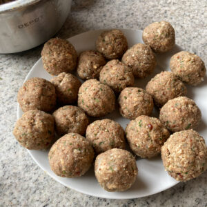 Kleine Leberknödel fertig gerollt auf Teller.