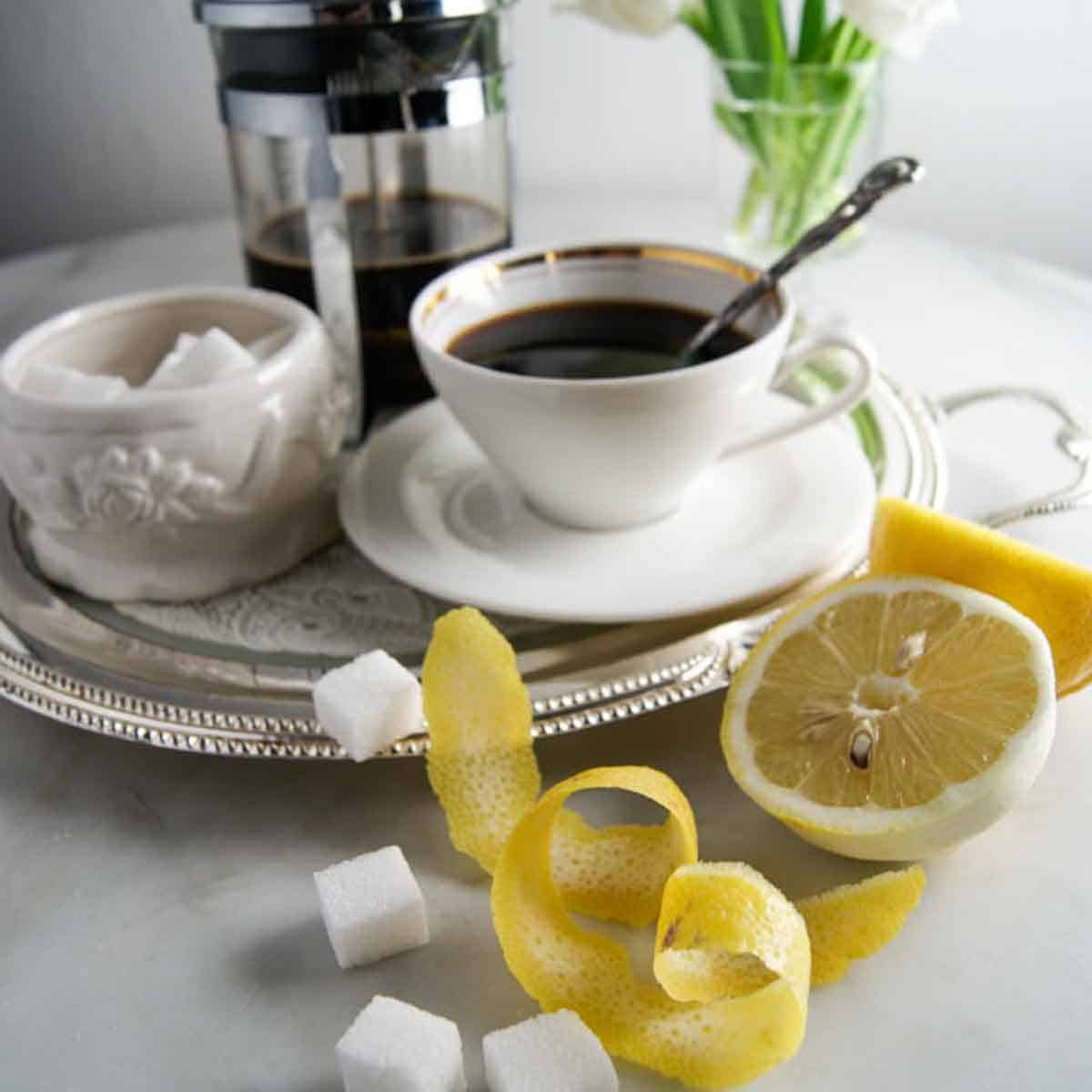 Katerkaffee mit Würfelzucker und Zitronenschale