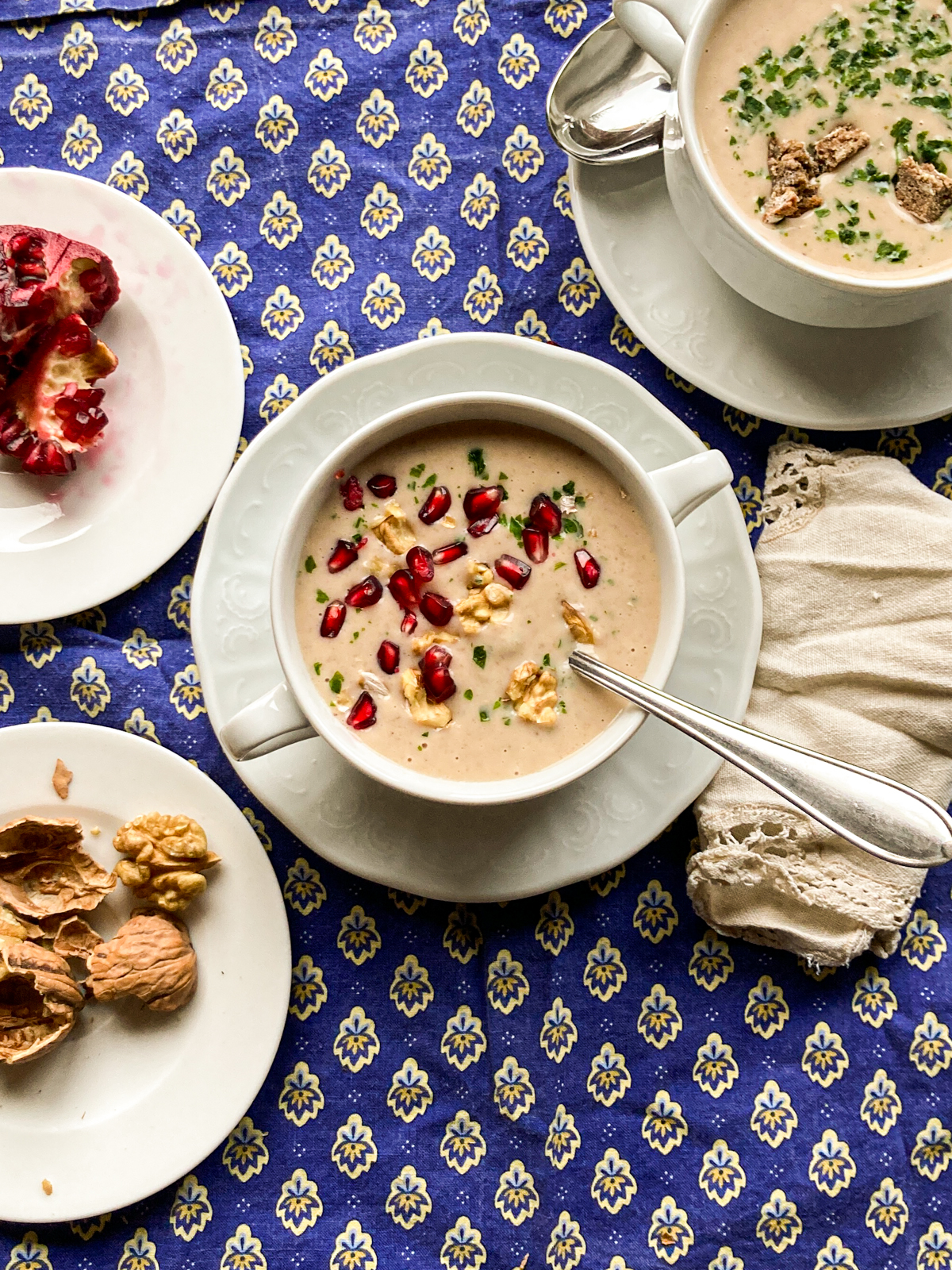 Suppenschüssel mit Maronicremesuppe mit Topping aus Walnüssen und Granatapfelkernen.