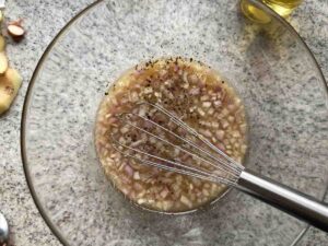 Erdäpfelsalat (Kartoffelsalat) Anleitung: Zwiebel, Senf und Rindersuppe mit Gewürzen verrühren.