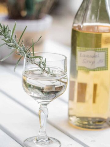 Lavendelsirup Sirup aufgespritzt in Glas verziert mit Lavendelblättern