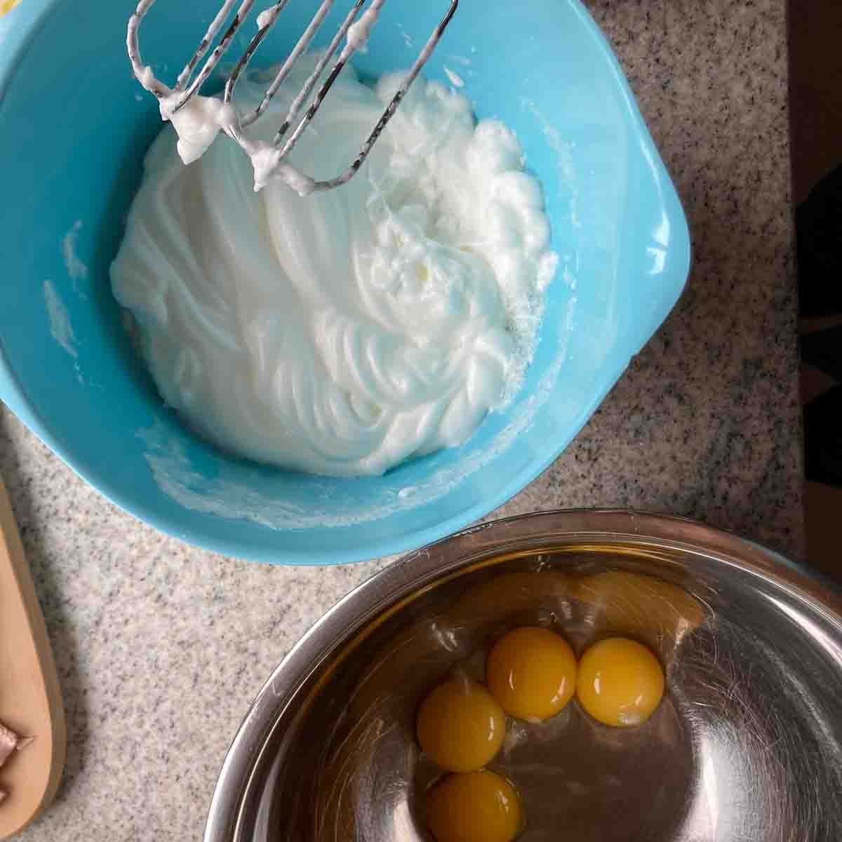 Schüsseln mit Eidotter und zweite Schüssel mit geschlagenem Eischnee - bowls with beaten egg whites and egg yolks.
