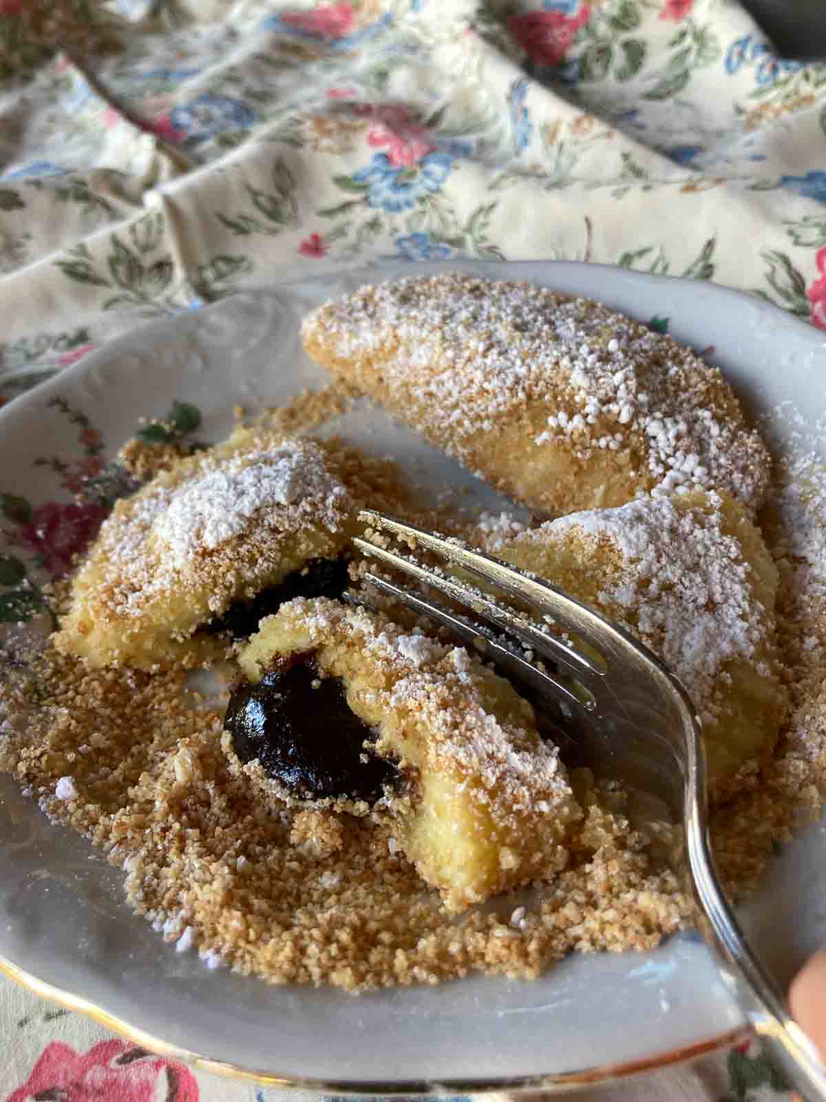 Powidltascherl gewälzt in gerösteten Bröseln, bestreut mit Staubzucker