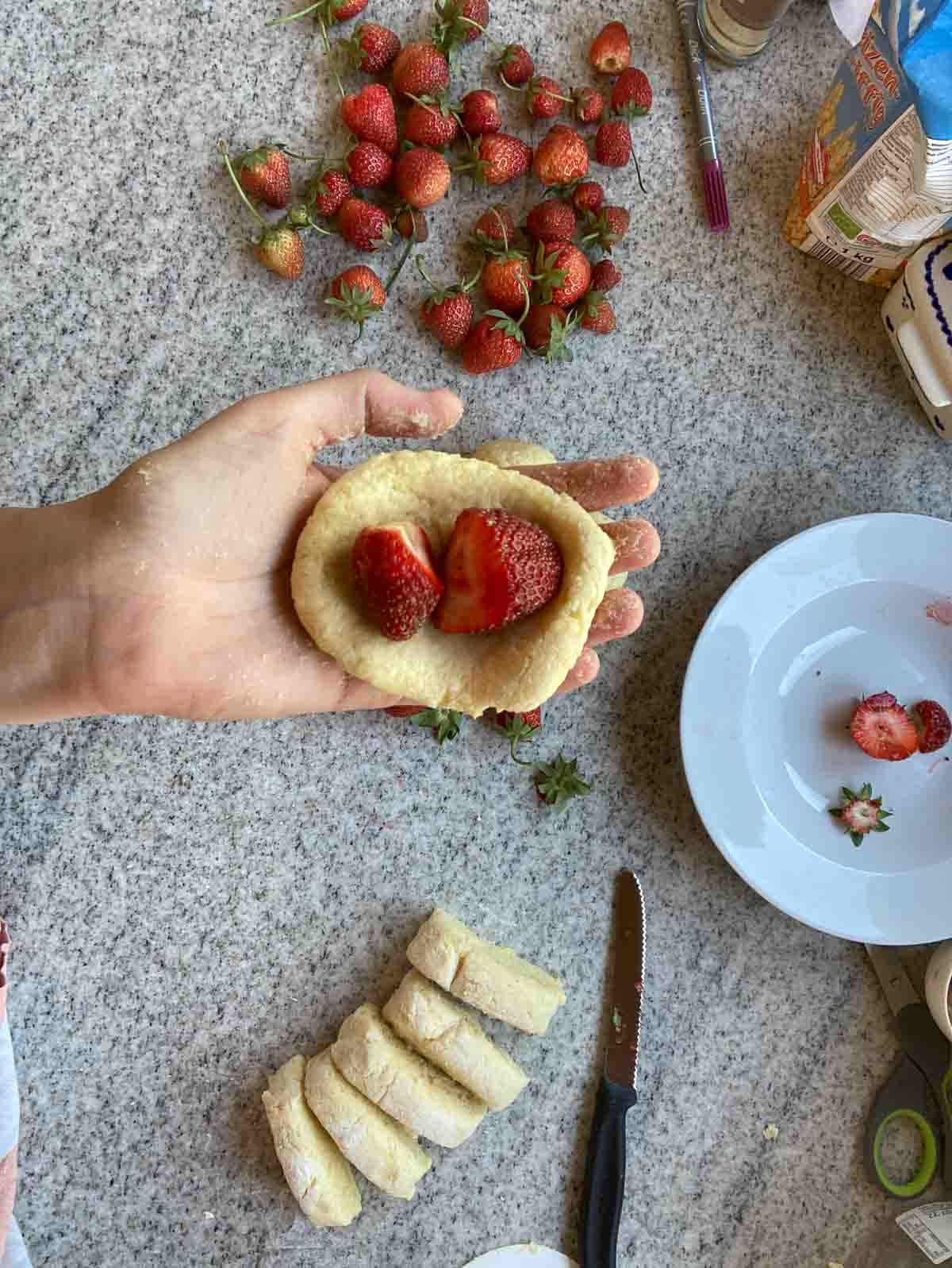 Erdbeerknödel mit zwei kleinen Erdbeeren füllen