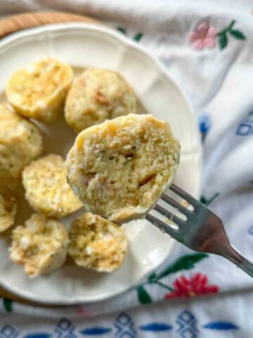 Semmelknödel auf Teller, ein halber Knödel auf Gabel aufgespießt.