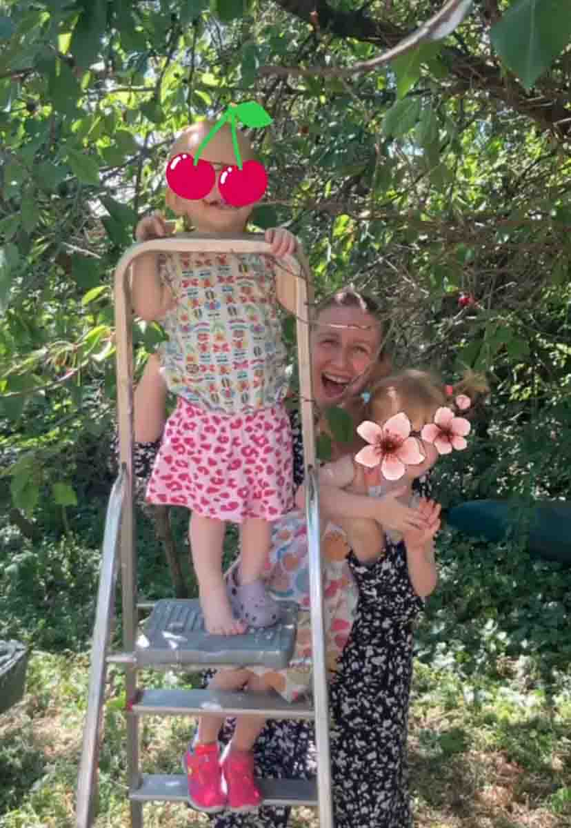 Angelika mit ihren zwei Töchtern beim Kirschenpflücken