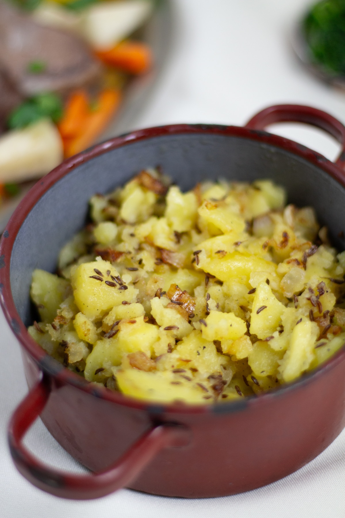 Erdäpfelschmarrn mit Kümmel in rustikalem Emailletopf | Pan roasted potatoes with caraway seeds in rustic pot.