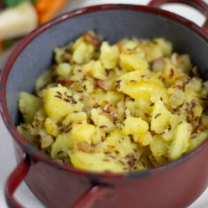 Erdäpfelschmarrn mit Kümmel in rustikalem Emailletopf | Pan roasted potatoes with caraway seeds in rustic pot.