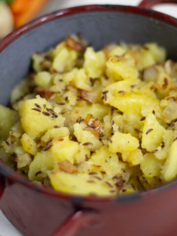 Erdäpfelschmarrn mit Kümmel in rustikalem Emailletopf | Pan roasted potatoes with caraway seeds in rustic pot.