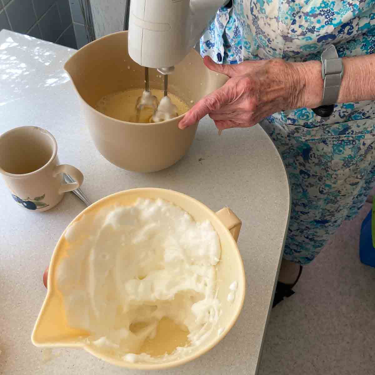 Schüssel mit Eiklar, das mit dem Mixer zu Eischnee geschlagen wird; zweite Schüssel für restlichen Teig.