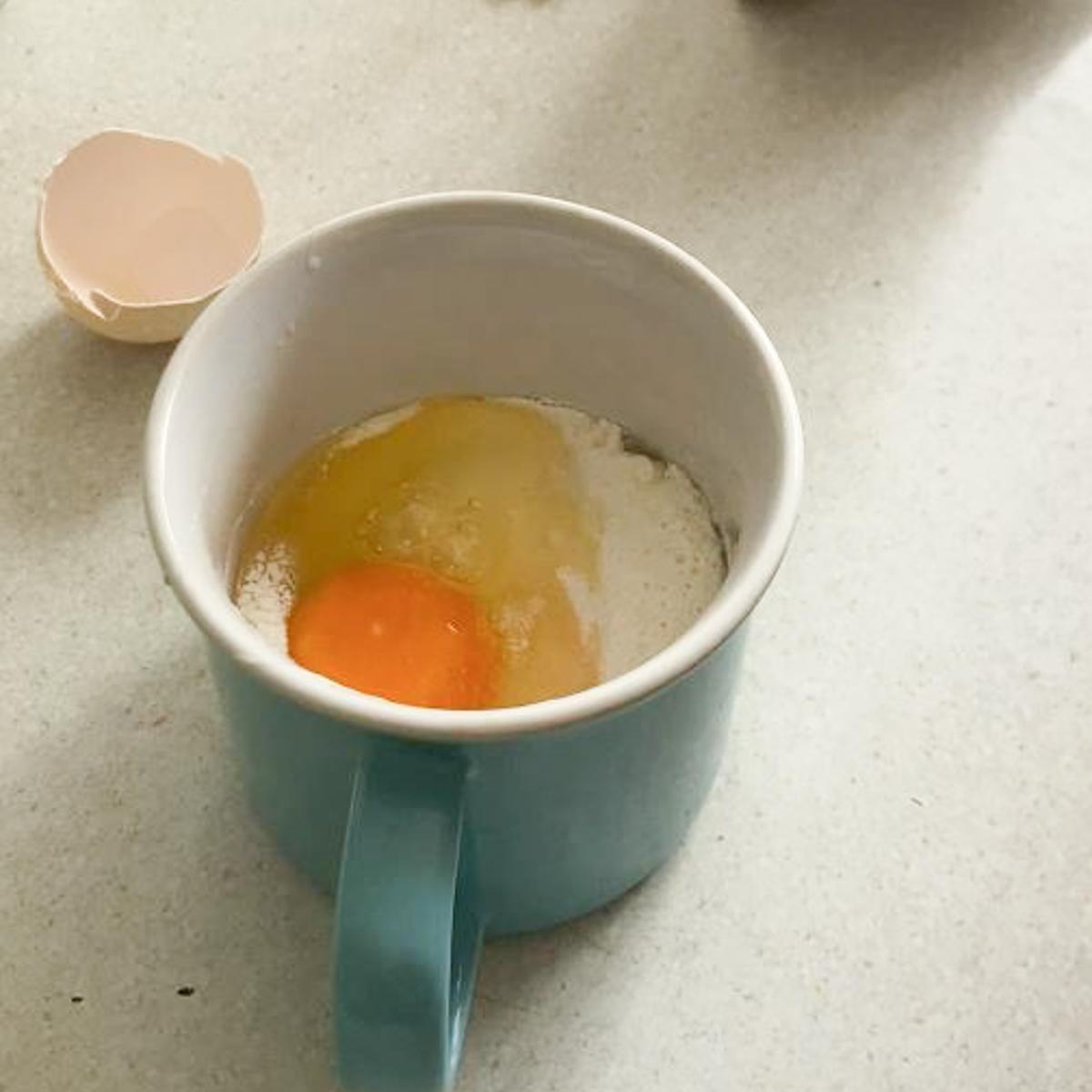 Ei aufgeschlagen in Becher mit Mehl.