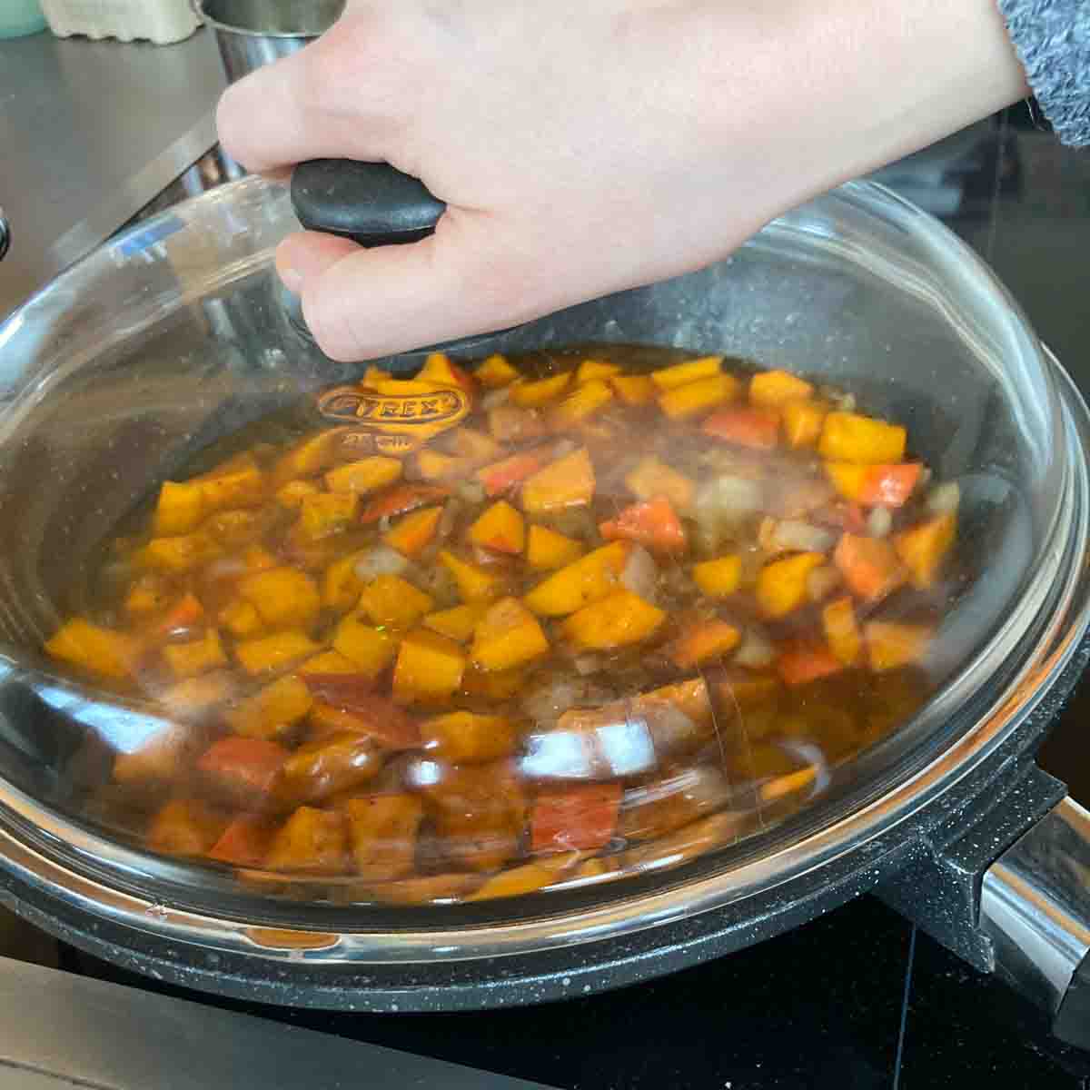 Sauerkrautpfanne mit Kürbis mit Deckel köcheln lassen.