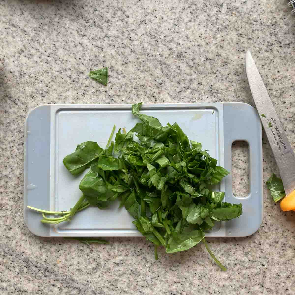 Chopped sorrel on plastic board.