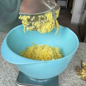 Erdäpfel durch Erdäpfelpresse drücken