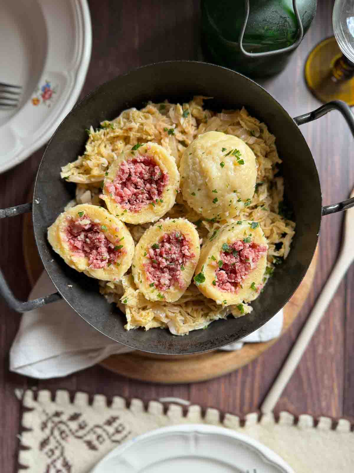 Selchfleischknödel auf Sauerkraut in gusseiserner Pfanne.