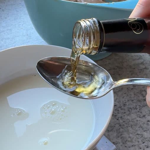 In einer Schüssel ca. 250 ml Milch mit den 3 bis 5 EL Rum vermischen.