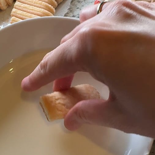 Jede Biskotte ienzeln in die Milch-Rum-Mischung eintauchen.