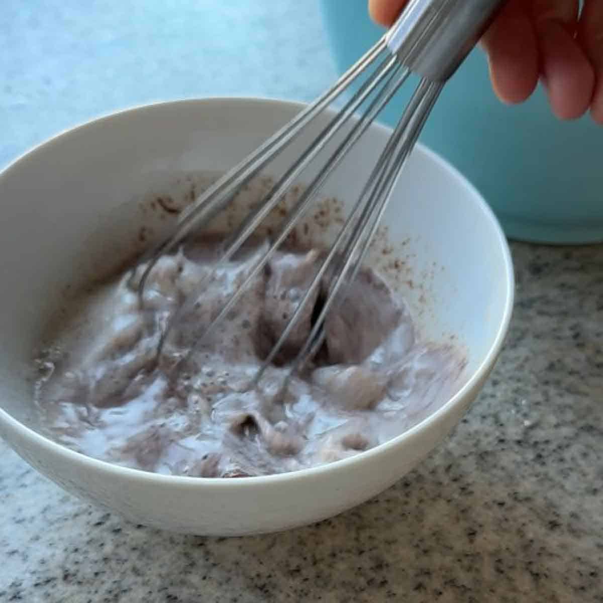 Geschmolzene Schokolade mit kalter Milch verrühren.