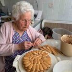 Oma beim Auflegen der Biskotten für die Biskottentorte.